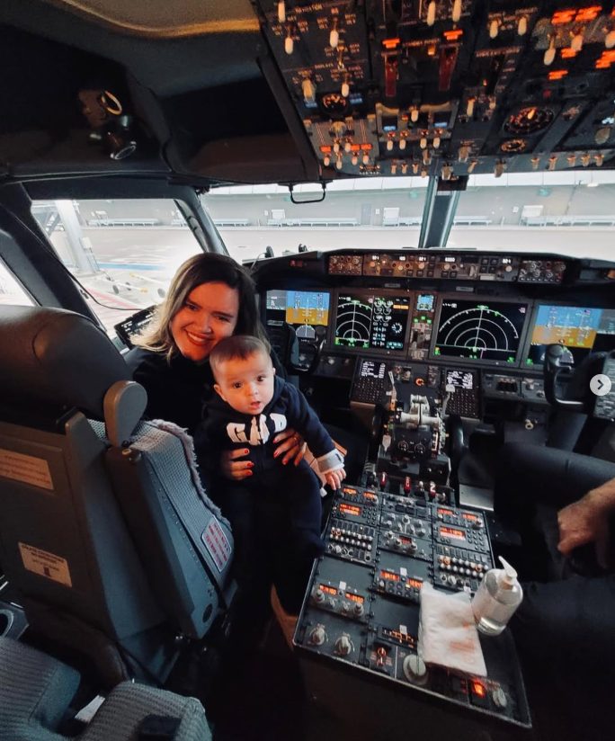 Pri com o Álvaro no colo dentro da cabine de um avião